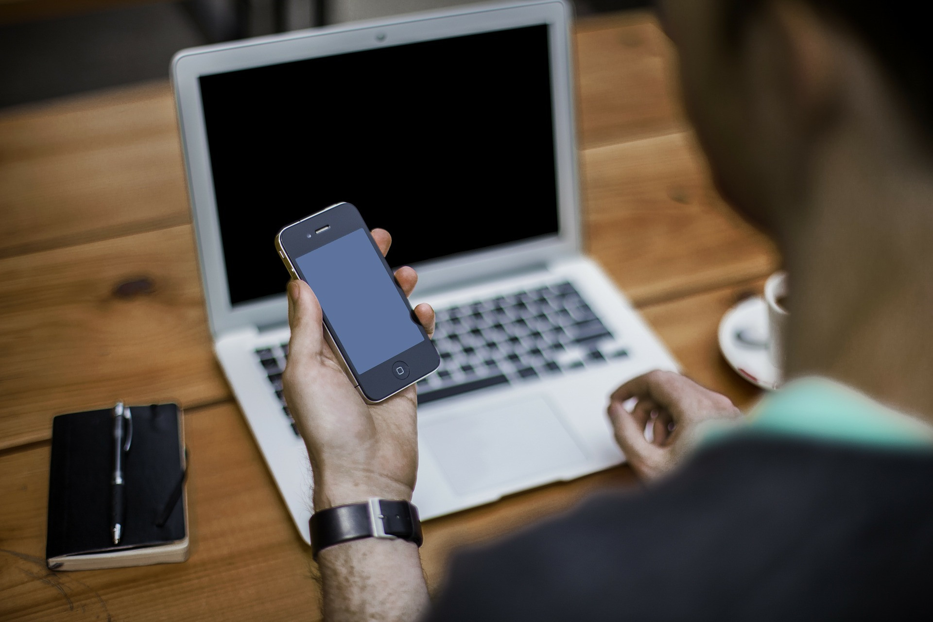 Un homme au bureau consulte son téléphone portable